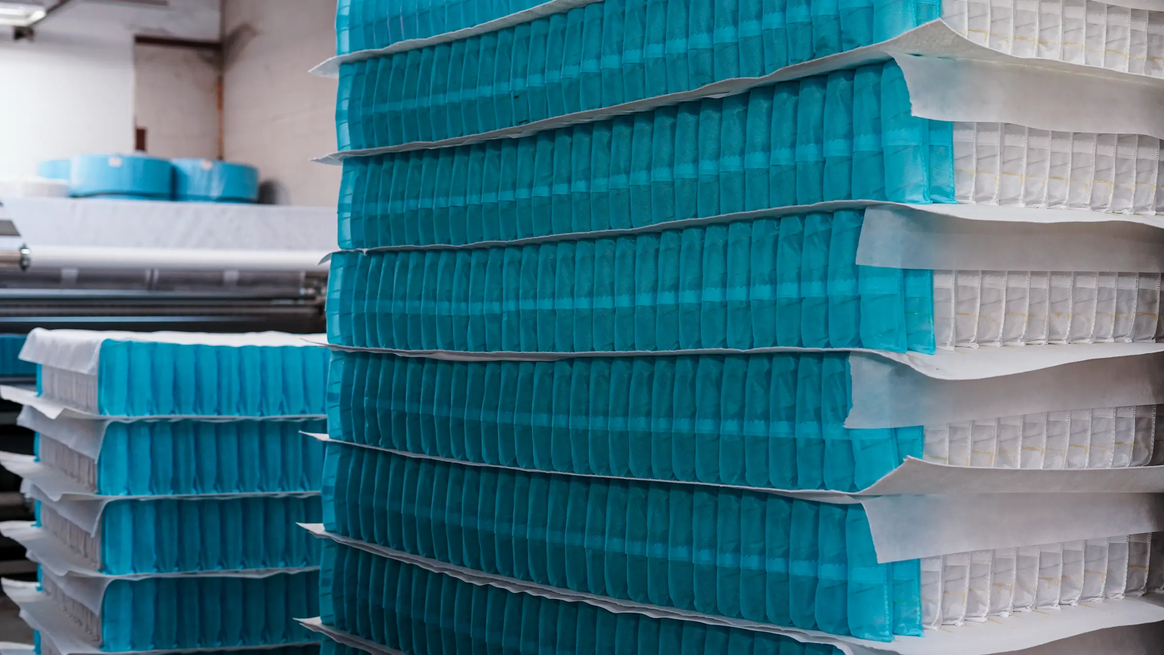Technicians inspecting mattress springs for quality